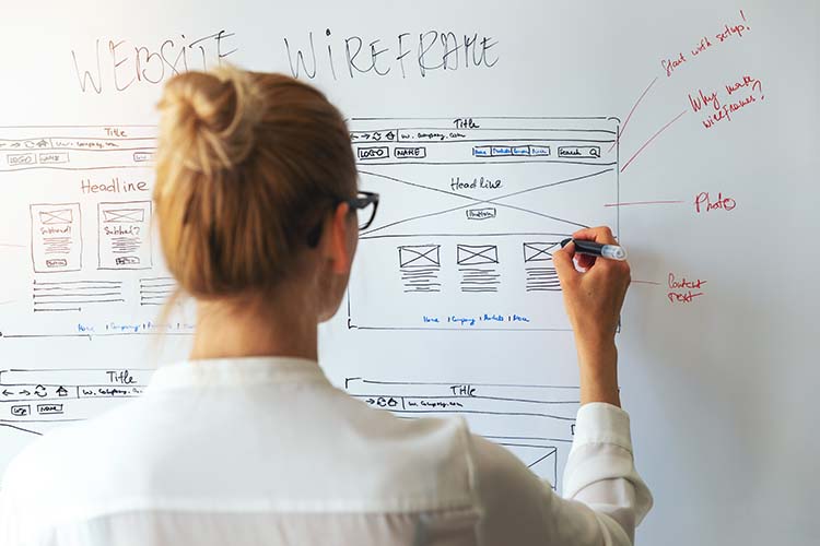 UI UX designer drawing new website redesign checklist and wireframe